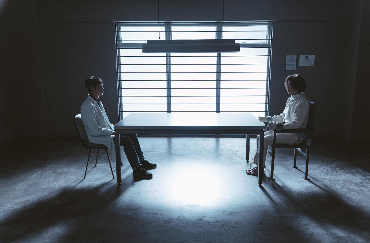 張家輝身穿病人服裝,雙手被緊鎖,與阿謙飾演的醫生對望,關係緊張。(《贖夢》劇照)