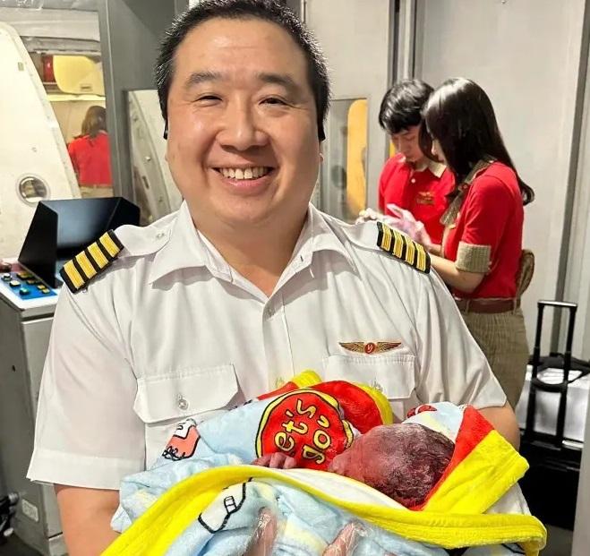 機長抱著他幫忙接生的男嬰時笑意盈盈,好有愛。(互聯網)