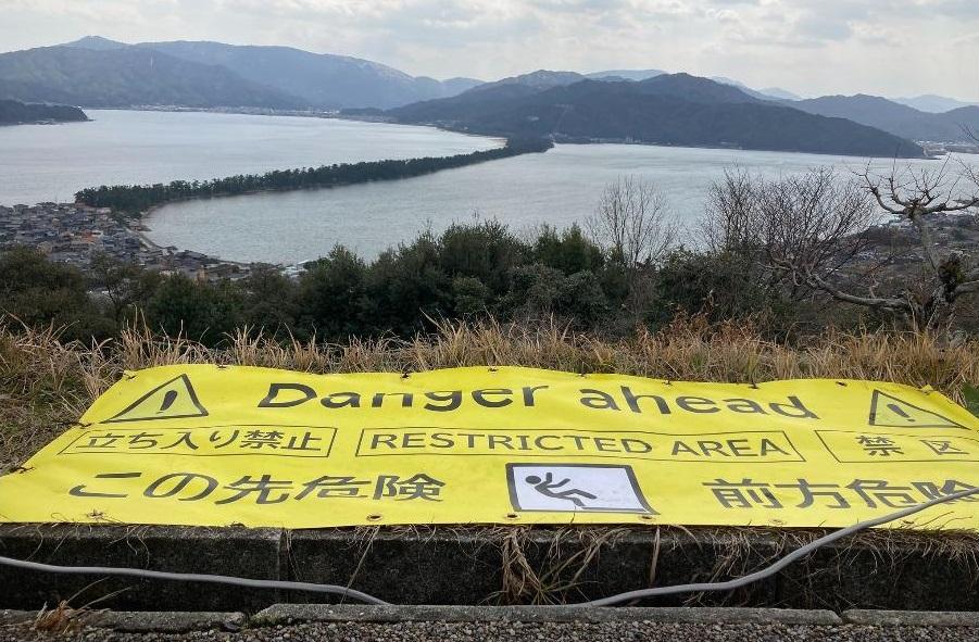 天橋立管理單位在觀景台拍照位置前方加放巨型黃色警告橫額。(互聯網)