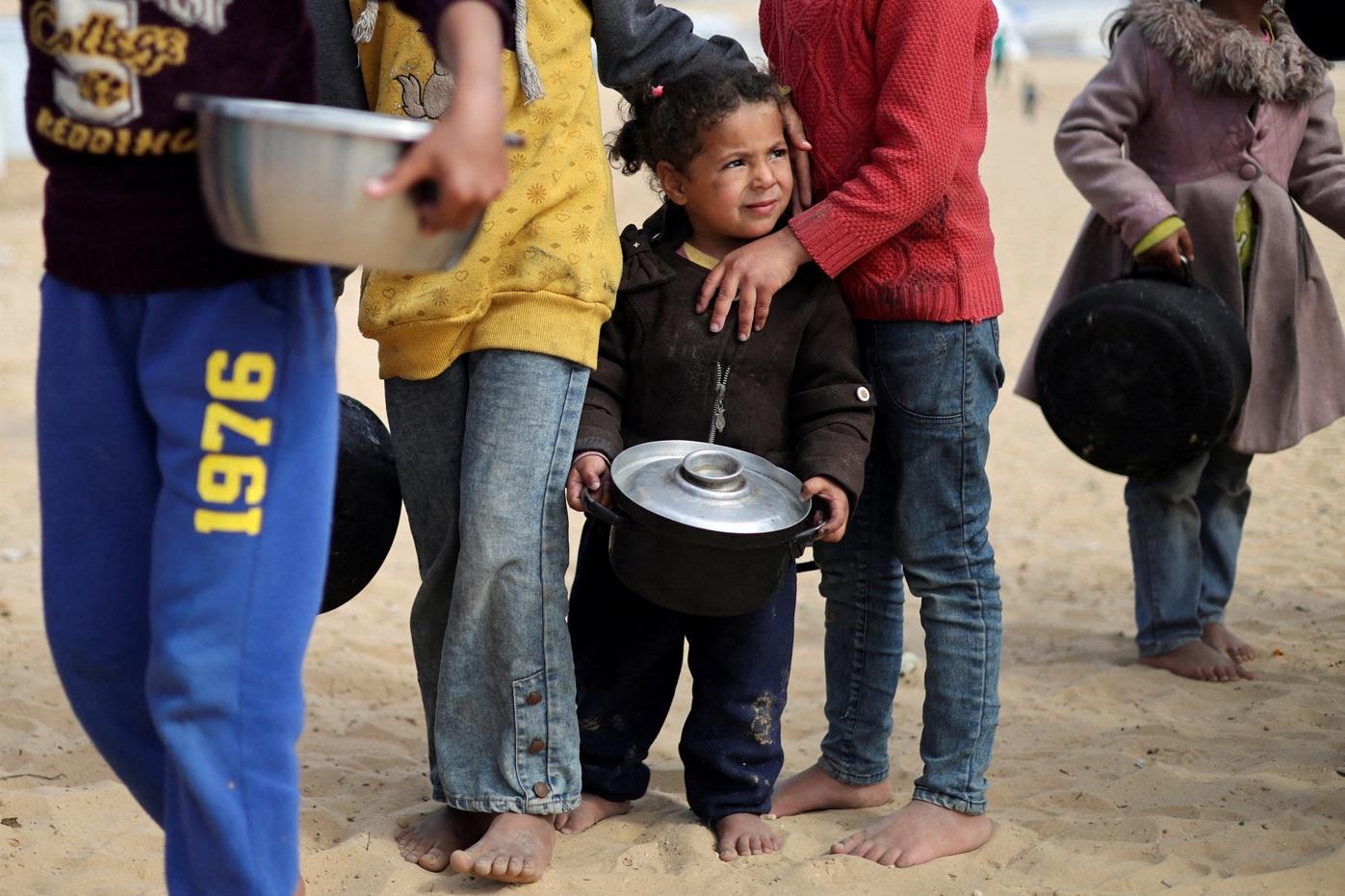 加沙南部拉法難民營兒童上月底輪候領取糧食。(路透社)