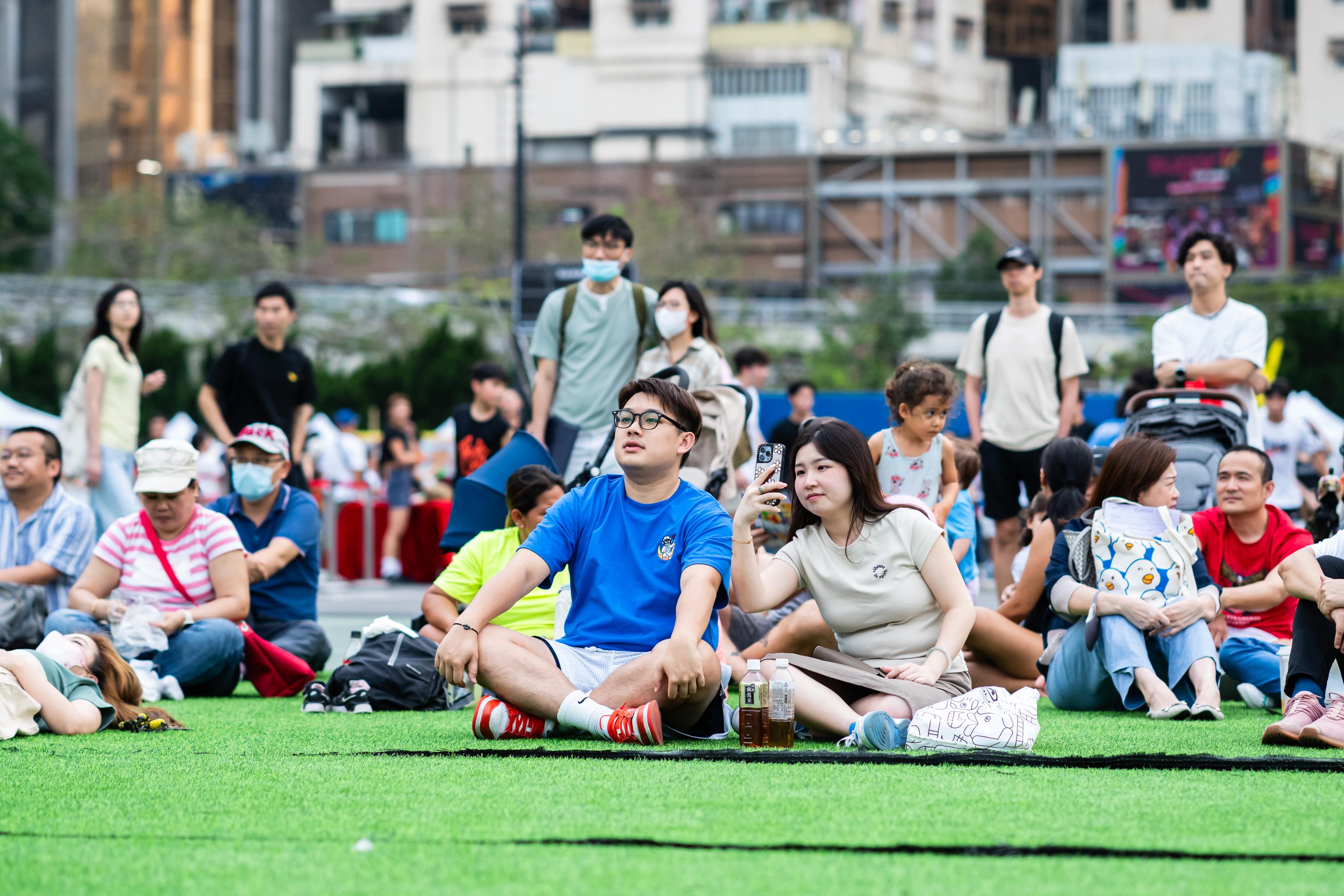 賽事全場爆滿,不少市民選擇在場外的人造草地觀賞直播。(大會提供)