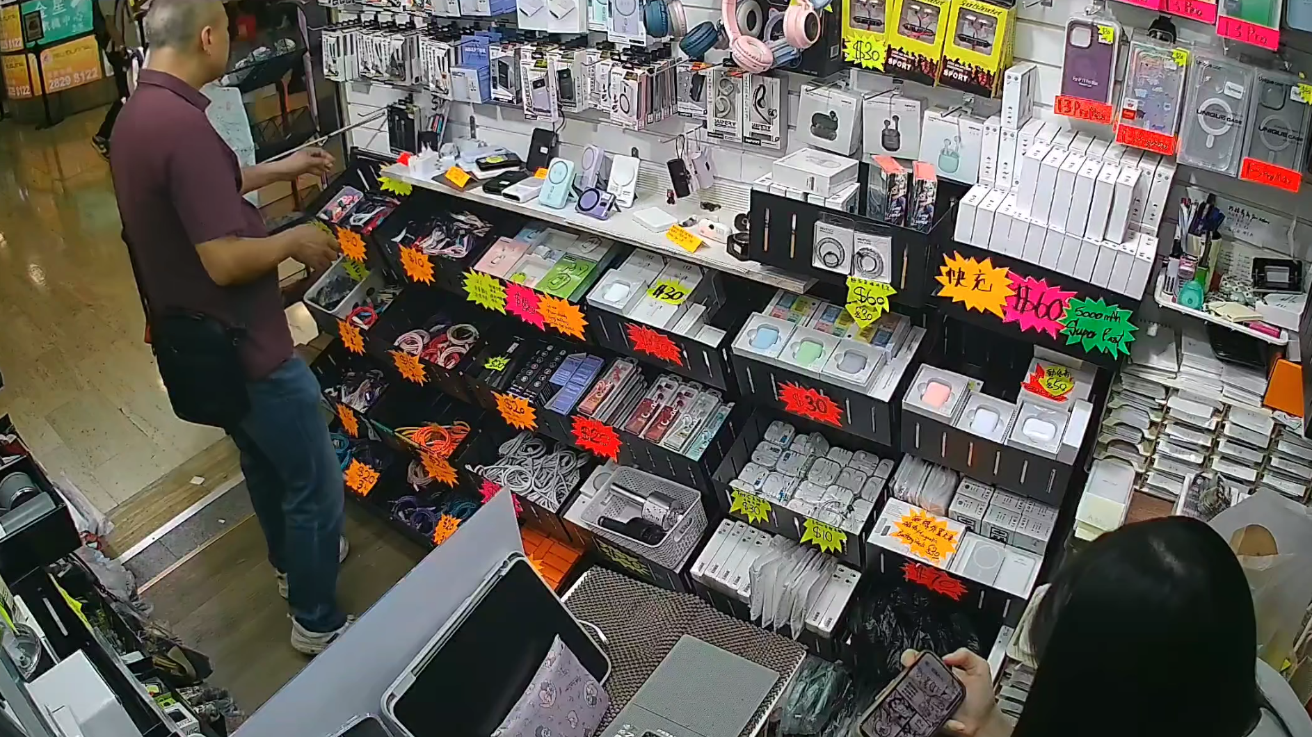 天眼影片顯示當日下午4時許,當時店內只有一名年輕女店員,該名半光頭男子在近門口位置挑選了一款約數十元的充電線,並以一張1,000元鈔票要求找贖,期間以普通話不斷叫女店員「便宜點」但被拒絕
