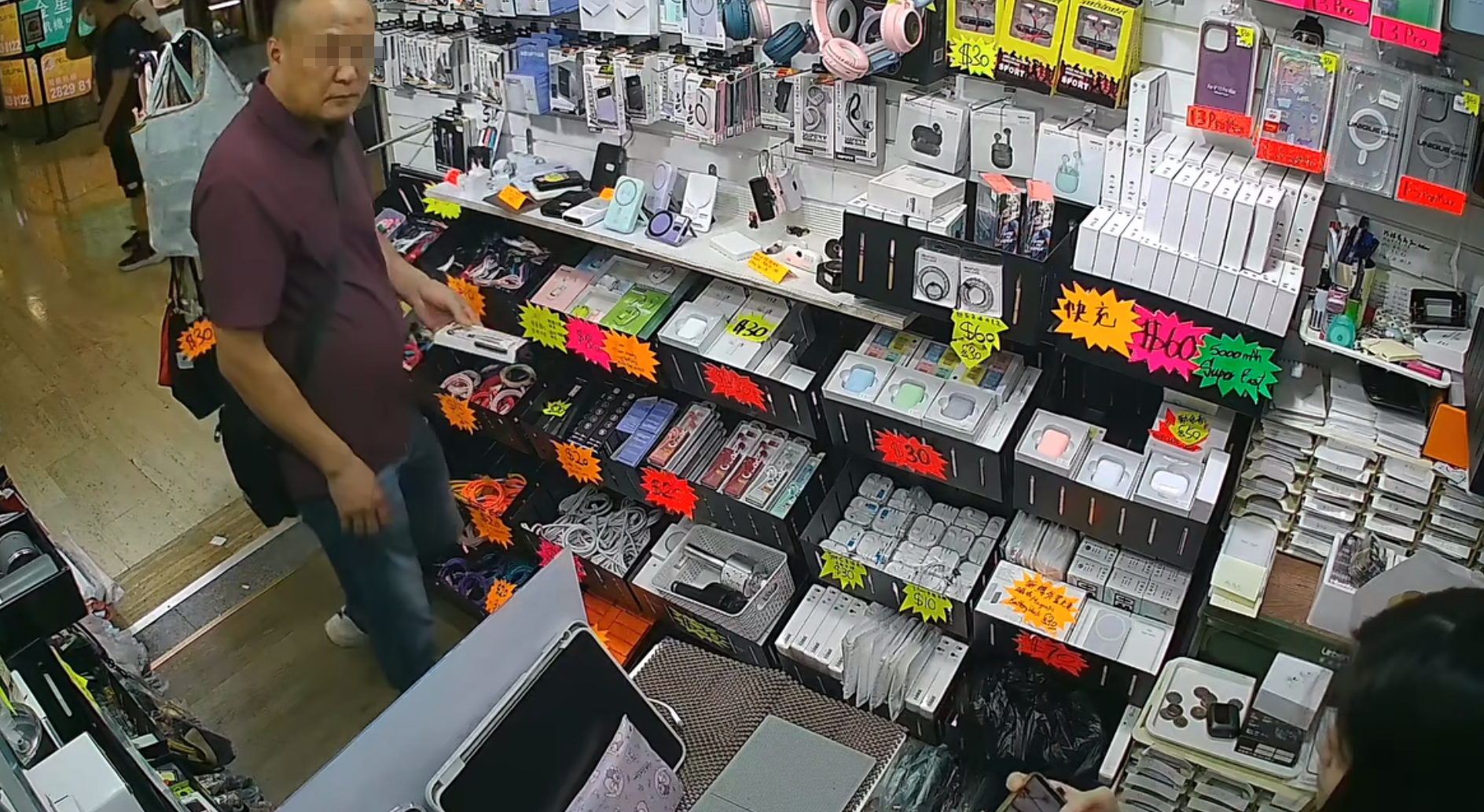天眼影片顯示當日下午4時許,當時店內只有一名年輕女店員,該名半光頭男子在近門口位置挑選了一款約數十元的充電線,並以一張1,000元鈔票要求找贖,期間以普通話不斷叫女店員「便宜點」但被拒絕