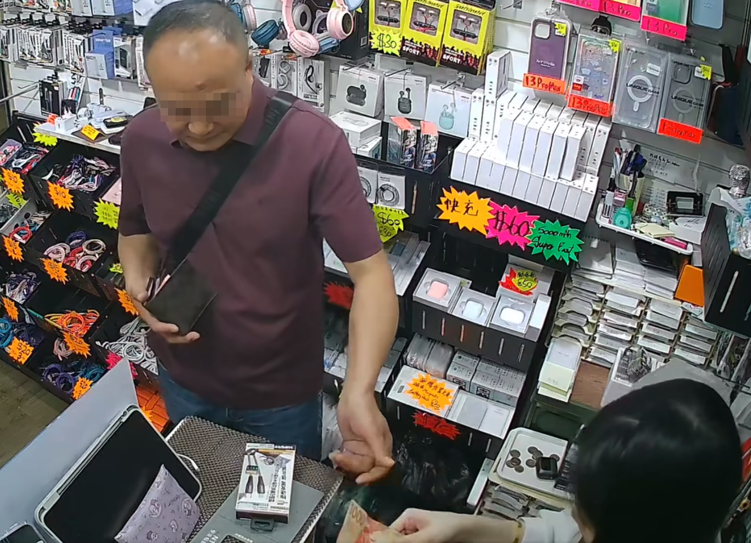 天眼影片顯示當日下午4時許,當時店內只有一名年輕女店員,該名半光頭男子在近門口位置挑選了一款約數十元的充電線,並以一張1,000元鈔票要求找贖,期間以普通話不斷叫女店員「便宜點」但被拒絕