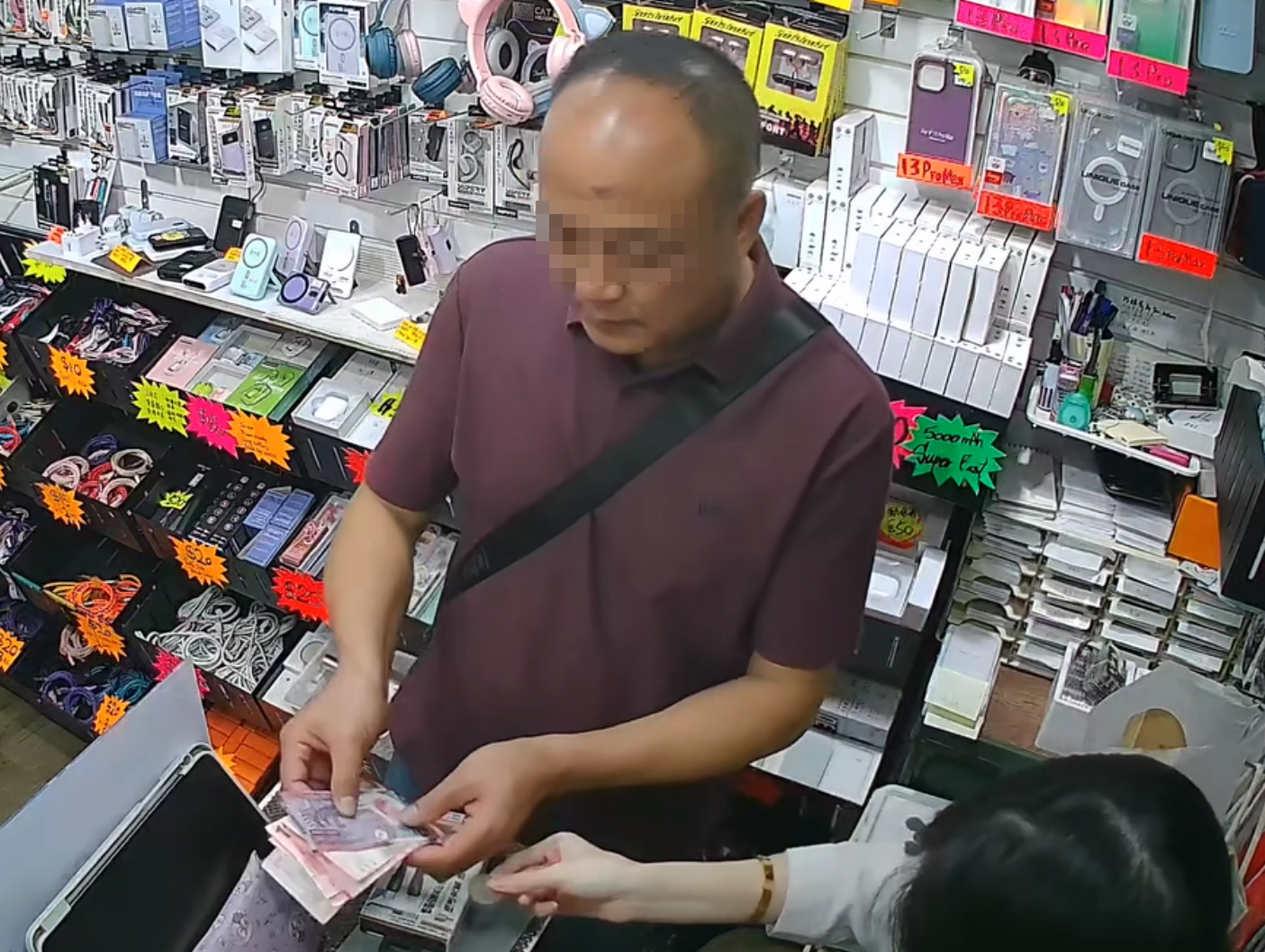 他突然開始議價,同時右手偷偷有所動作,疑將最底部的500元紙幣偷偷對摺,藏在掌心偷走。