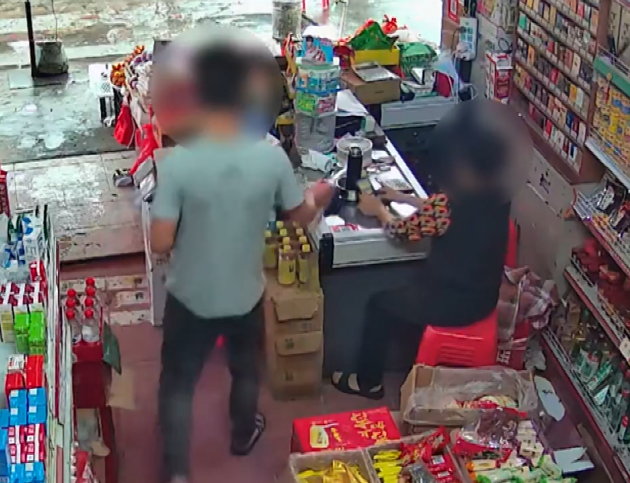 他走到收銀台拿了兩包煙,並拿出手機開始掃碼「付款」(影片截圖)