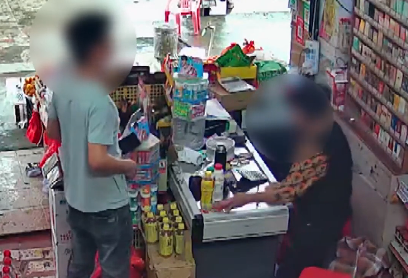他走到收銀台拿了兩包煙,並拿出手機開始掃碼「付款」(影片截圖)