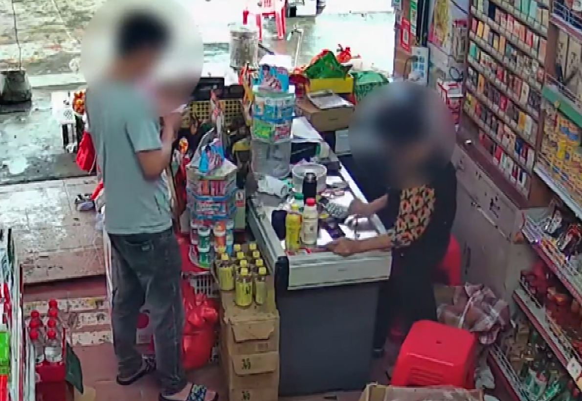 他走到收銀台拿了兩包煙,並拿出手機開始掃碼「付款」(影片截圖)