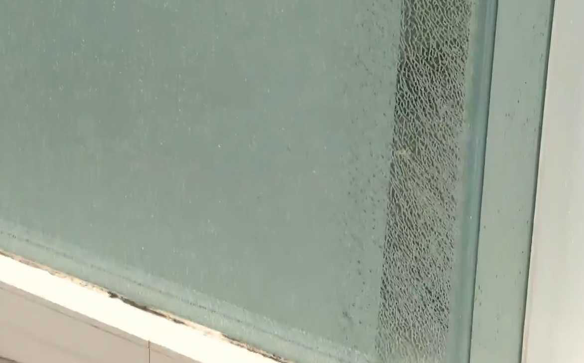 水柱更噴射對面大廈轉角一間銀行,銀行內輕微積水,落地玻璃出現裂紋,有提款機及入票機損壞需暫停服務。(有線新聞畫面)