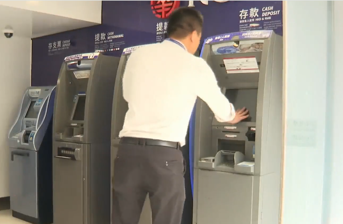 水柱更噴射對面大廈轉角一間銀行,銀行內輕微積水,落地玻璃出現裂紋,有提款機及入票機損壞需暫停服務。(有線新聞畫面)