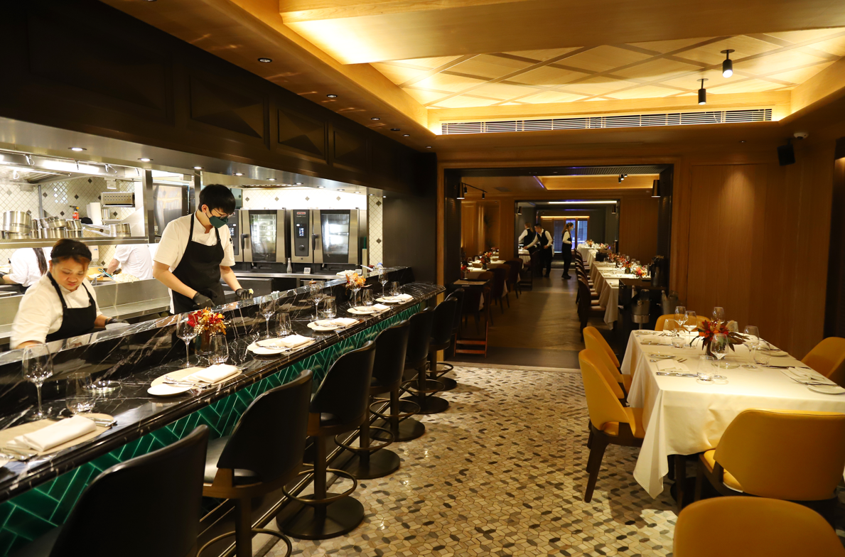 餐廳中央位置設有開放式廚房和吧檯座位,讓用餐者可在品嚐美食時一窺各款美饌的烹煮過程。(攝:羅錦鴻)