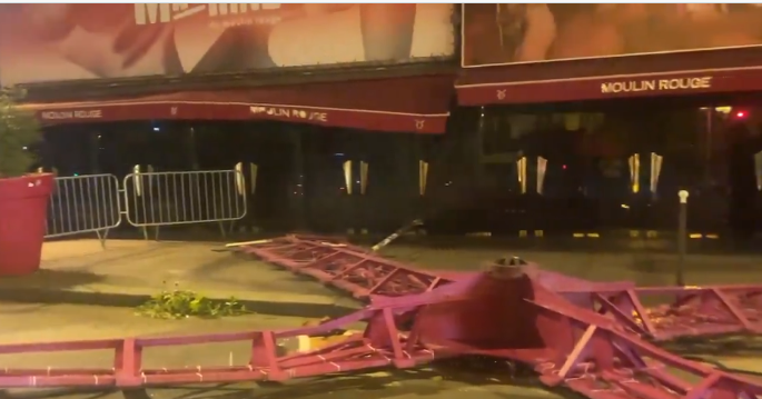 法國巴黎著名地標紅磨坊(Moulin Rouge)的風車葉片倒塌街頭,幸未造成任何人員受傷。(影片截圖)