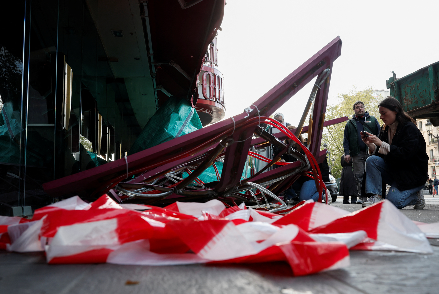 法國巴黎著名地標紅磨坊(Moulin Rouge)的風車葉片倒塌街頭,幸未造成任何人員受傷。(路透社)