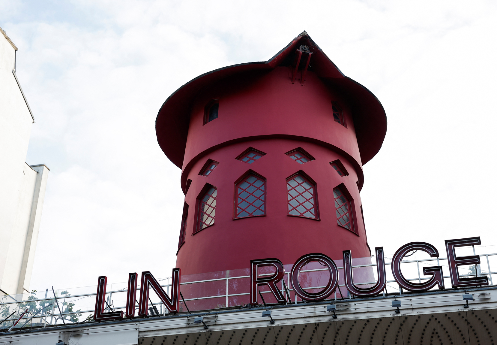 法國巴黎著名地標紅磨坊(Moulin Rouge)的風車葉片倒塌街頭,幸未造成任何人員受傷。(路透社)
