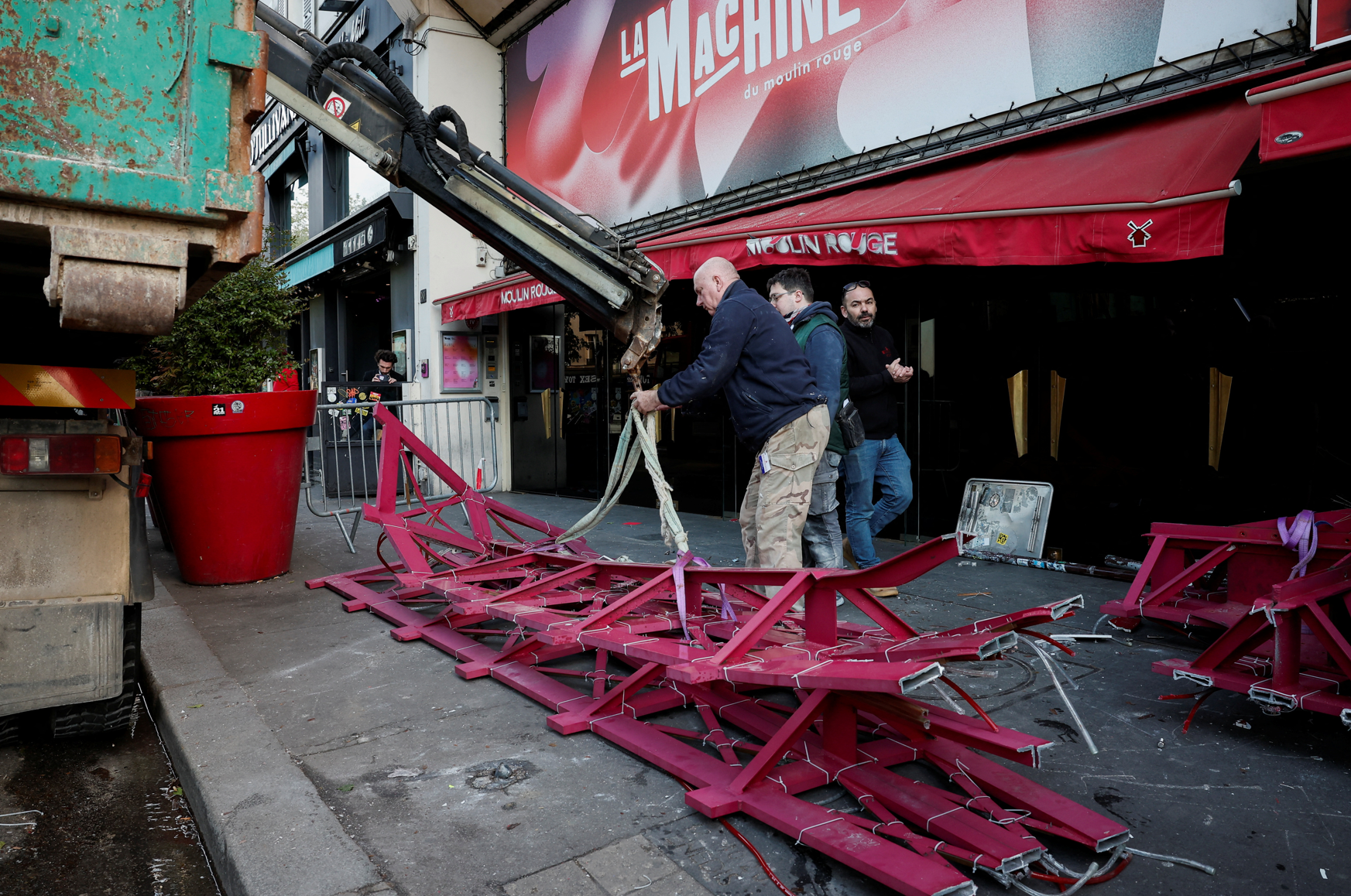 法國巴黎著名地標紅磨坊(Moulin Rouge)的風車葉片倒塌街頭,幸未造成任何人員受傷。(路透社)