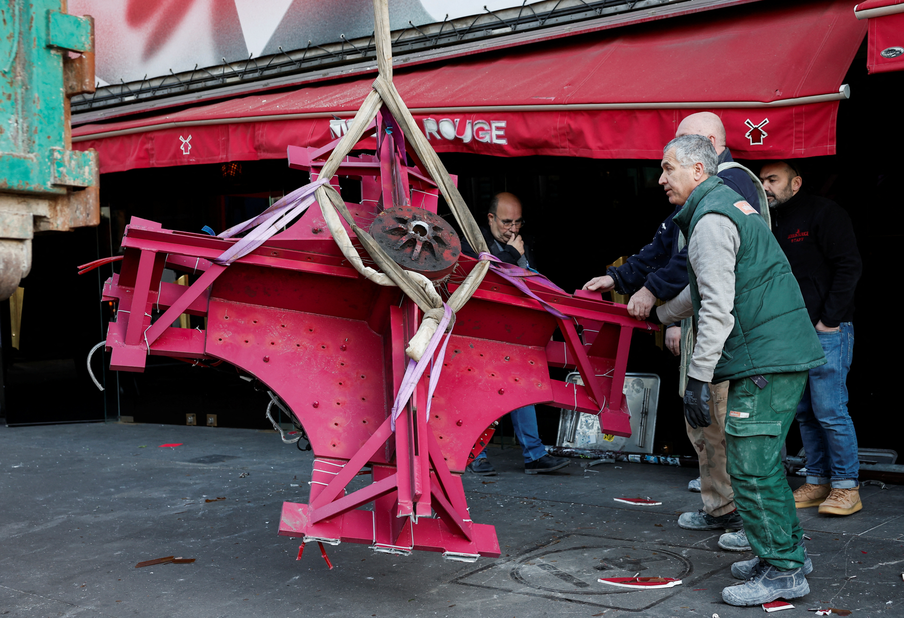 法國巴黎著名地標紅磨坊(Moulin Rouge)的風車葉片倒塌街頭,幸未造成任何人員受傷。(路透社)