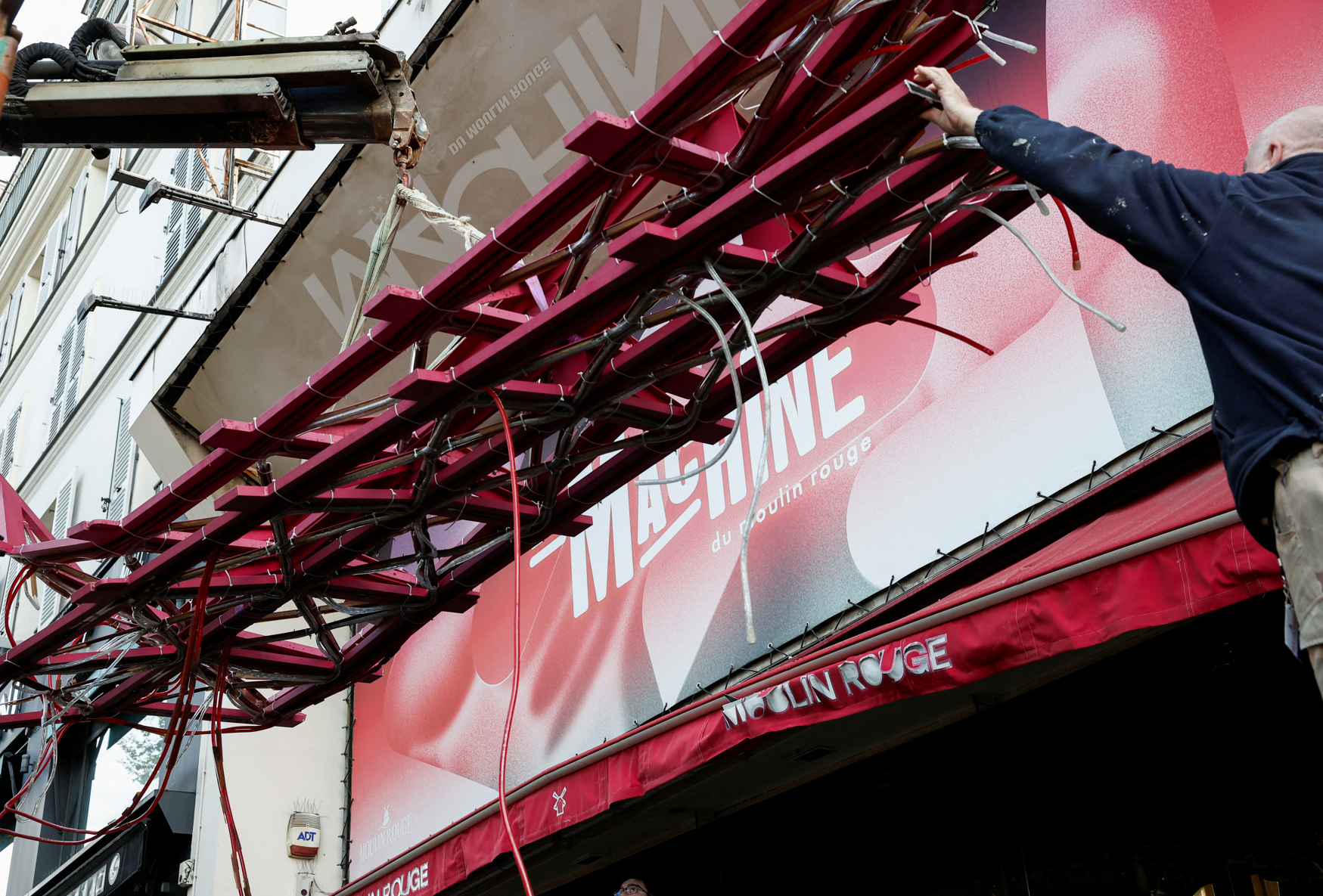 法國巴黎著名地標紅磨坊(Moulin Rouge)的風車葉片倒塌街頭,幸未造成任何人員受傷。(路透社)