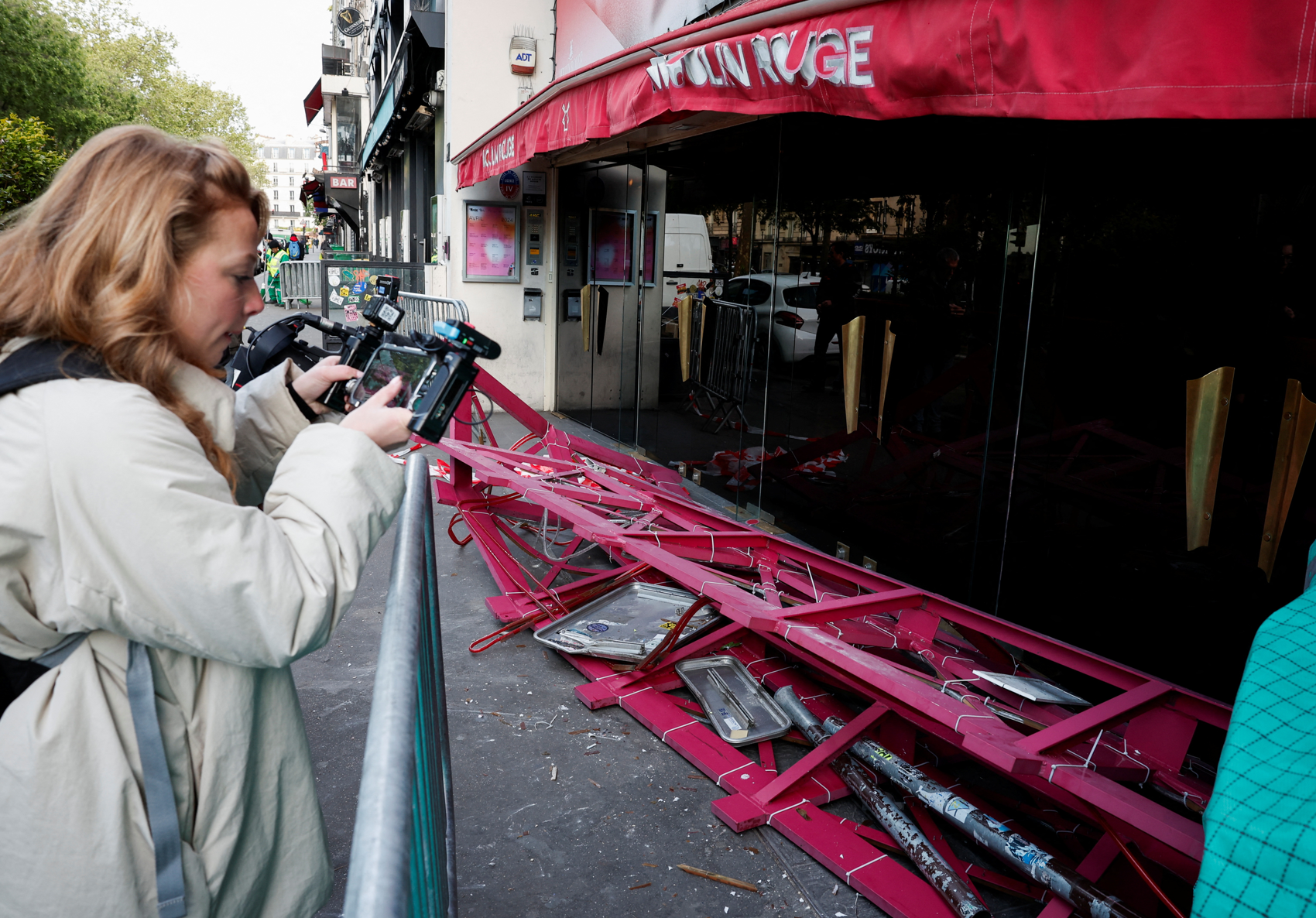 法國巴黎著名地標紅磨坊(Moulin Rouge)的風車葉片倒塌街頭,幸未造成任何人員受傷。(路透社)