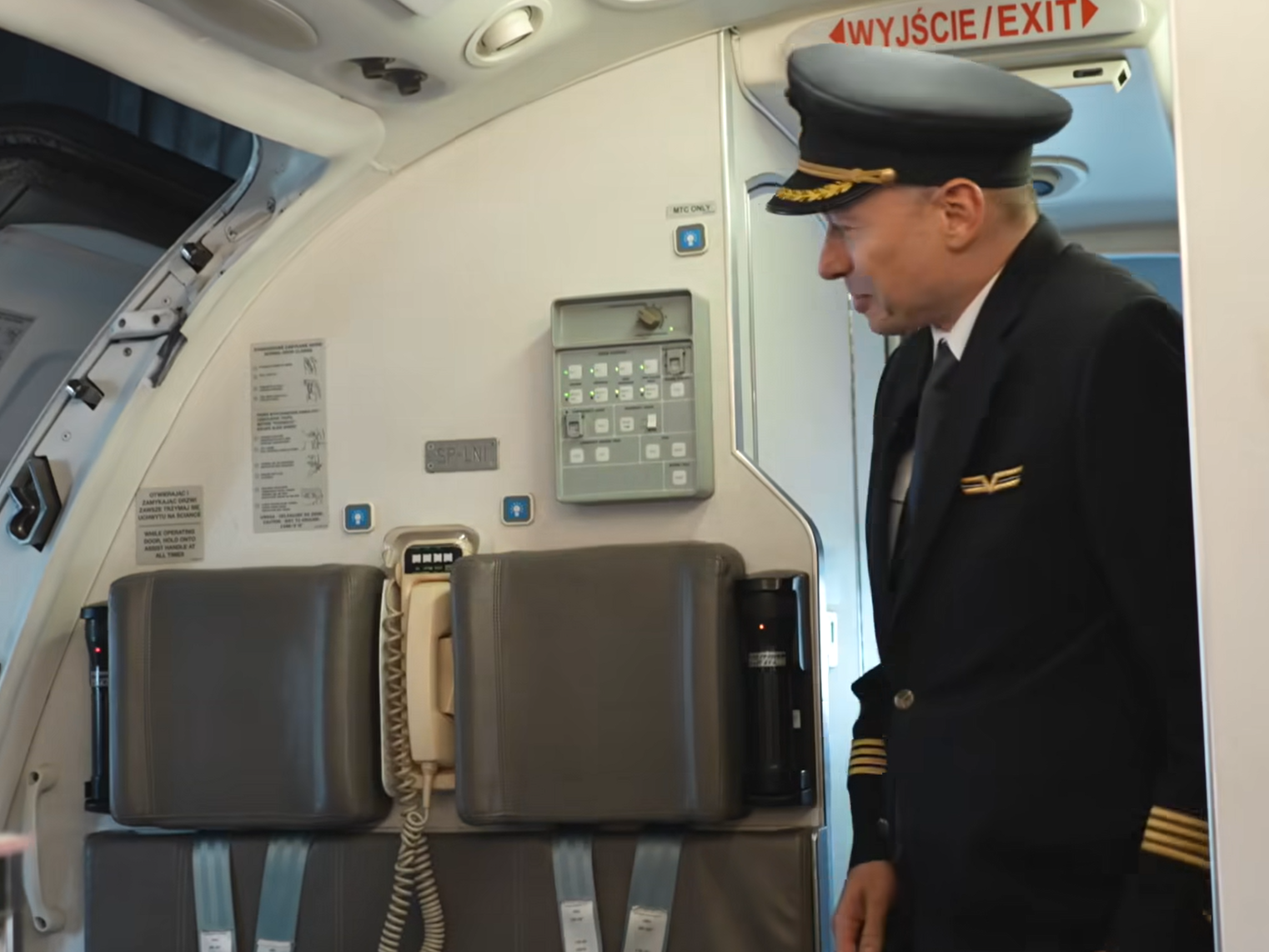 波蘭航空一班客機上演一幕浪漫求婚場面,駕駛航班的機長漢克向乘客廣播到一半時,單膝下跪向同機的空姐女友寶拉求婚。(波蘭航空fb影片截圖)