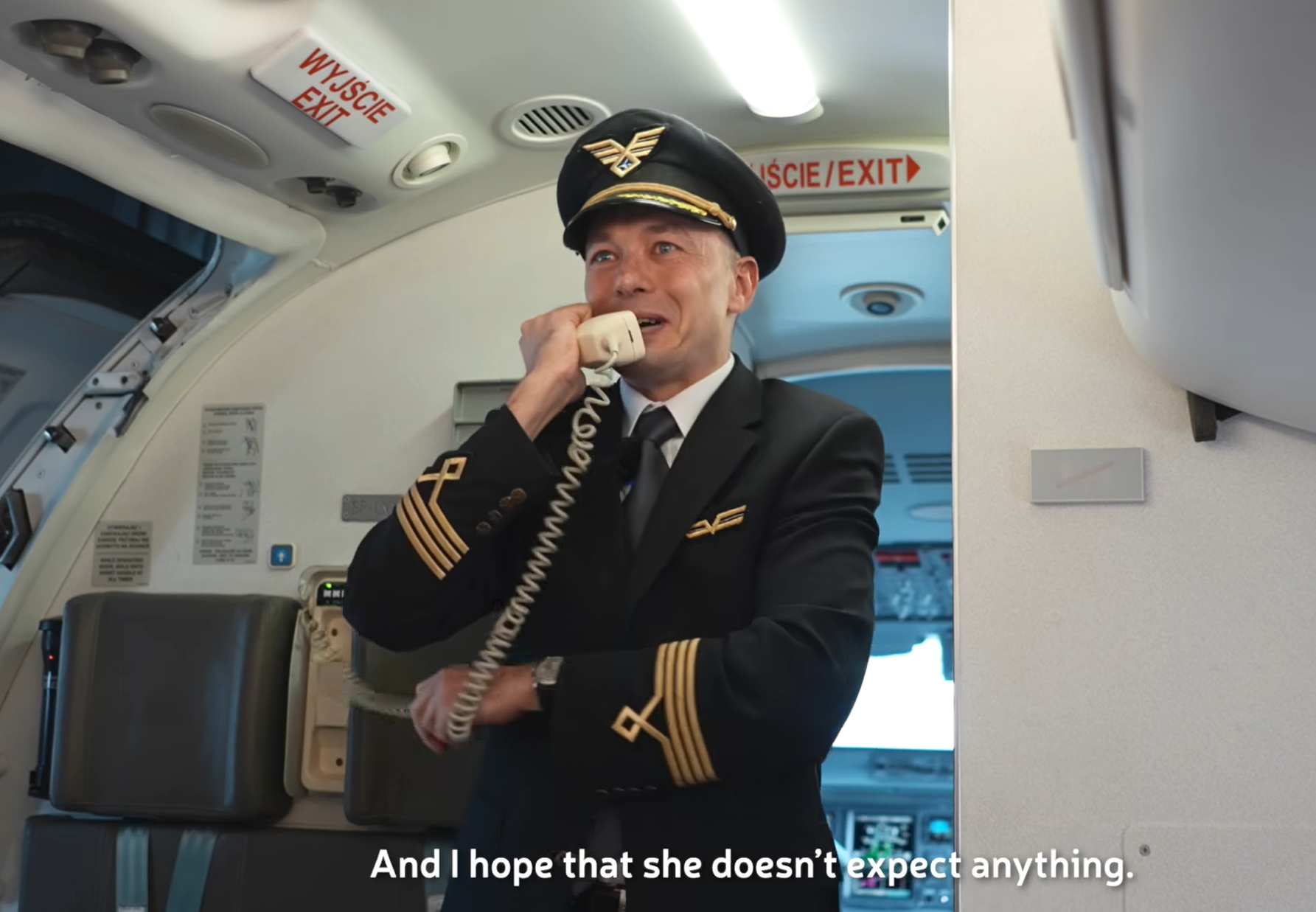 波蘭航空一班客機上演一幕浪漫求婚場面,駕駛航班的機長漢克向乘客廣播到一半時,單膝下跪向同機的空姐女友寶拉求婚。(波蘭航空fb影片截圖)