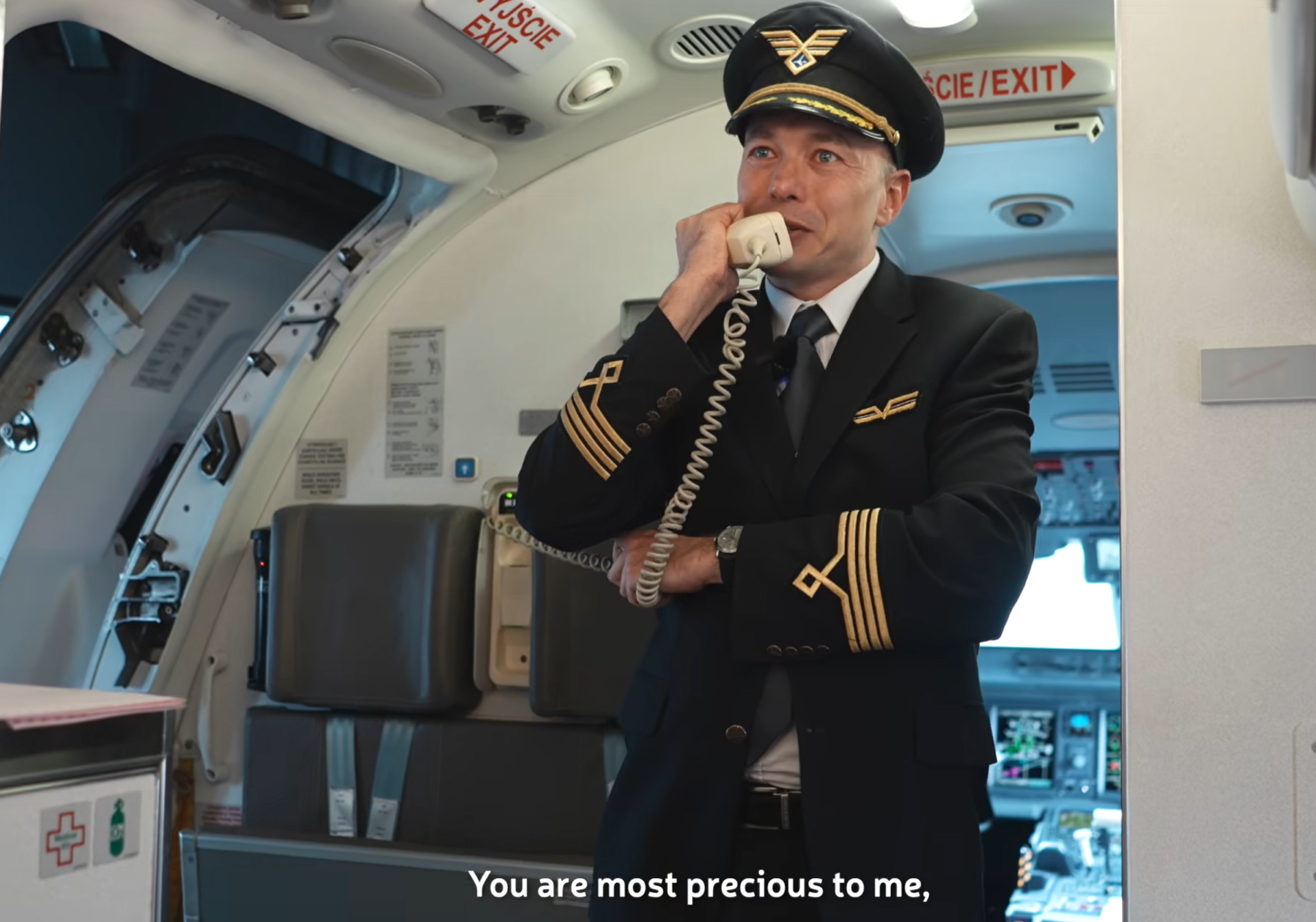 波蘭航空一班客機上演一幕浪漫求婚場面,駕駛航班的機長漢克向乘客廣播到一半時,單膝下跪向同機的空姐女友寶拉求婚。(波蘭航空fb影片截圖)