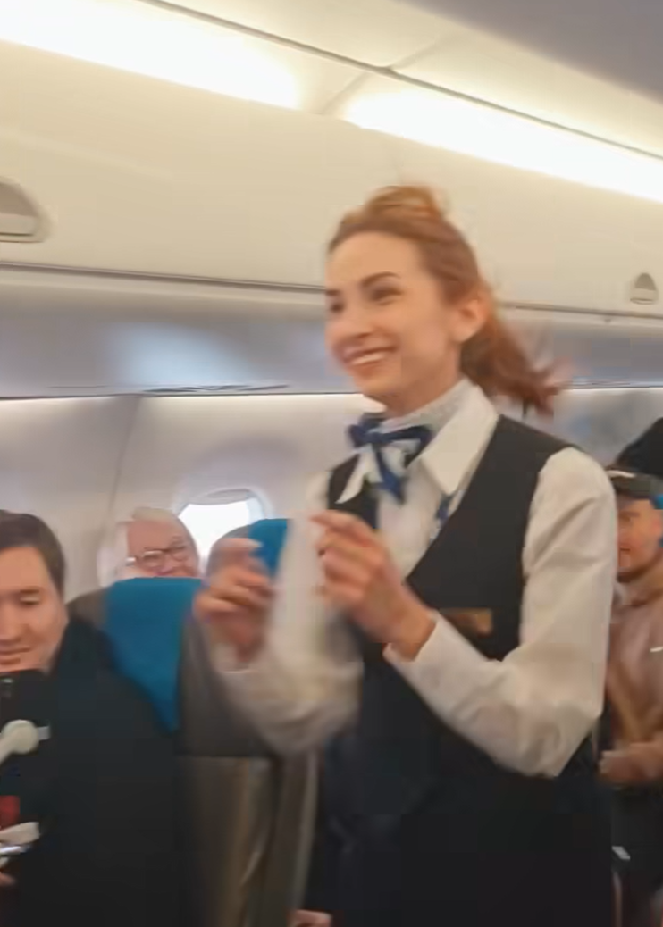 波蘭航空一班客機上演一幕浪漫求婚場面,駕駛航班的機長漢克向乘客廣播到一半時,單膝下跪向同機的空姐女友寶拉求婚。(波蘭航空fb影片截圖)