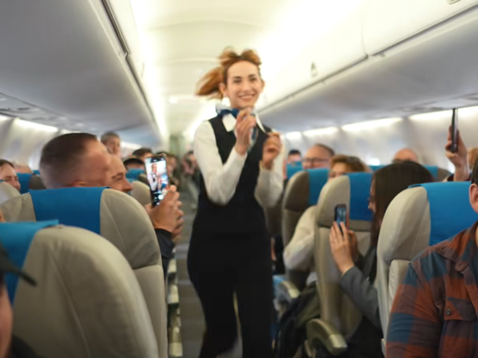 波蘭航空一班客機上演一幕浪漫求婚場面,駕駛航班的機長漢克向乘客廣播到一半時,單膝下跪向同機的空姐女友寶拉求婚。(波蘭航空fb影片截圖)