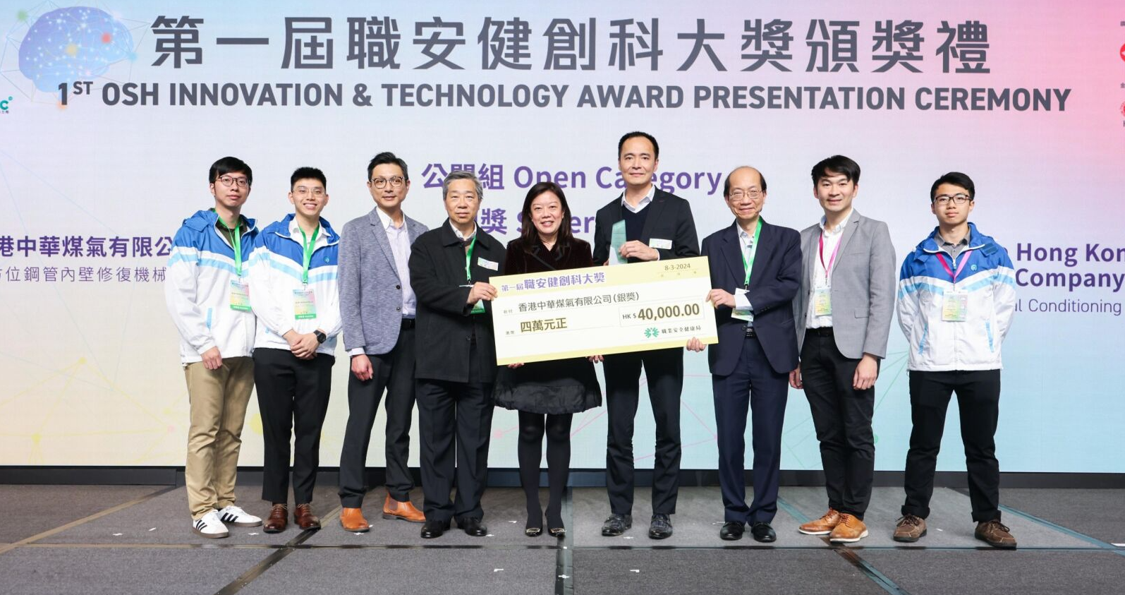 煤氣公司總經理 — 配氣操作黎錦圖(右四)及「全方位鋼管內壁修復機械人」項目研發團隊,代表接受由勞工處處長陳穎韶(中)頒發的第一屆「職安健創科大獎」公開組銀獎。