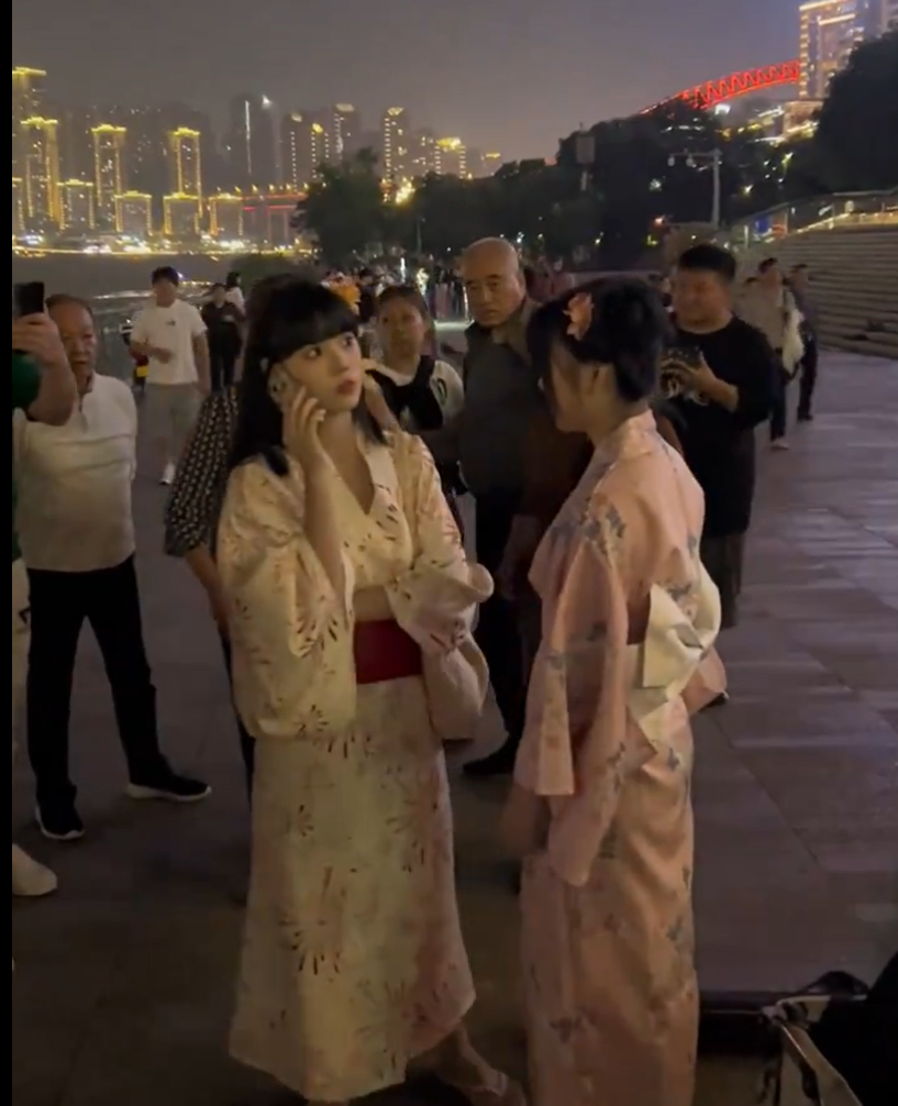 重慶市兩名女子上周六(27日)在南濱路博覽館前,穿着和服跳舞並拍攝影片,吸引路人圍觀,期間有一群長者聲討制止表不滿,雙方一度有肢體衝突,最終公安介入。(影片截圖)
