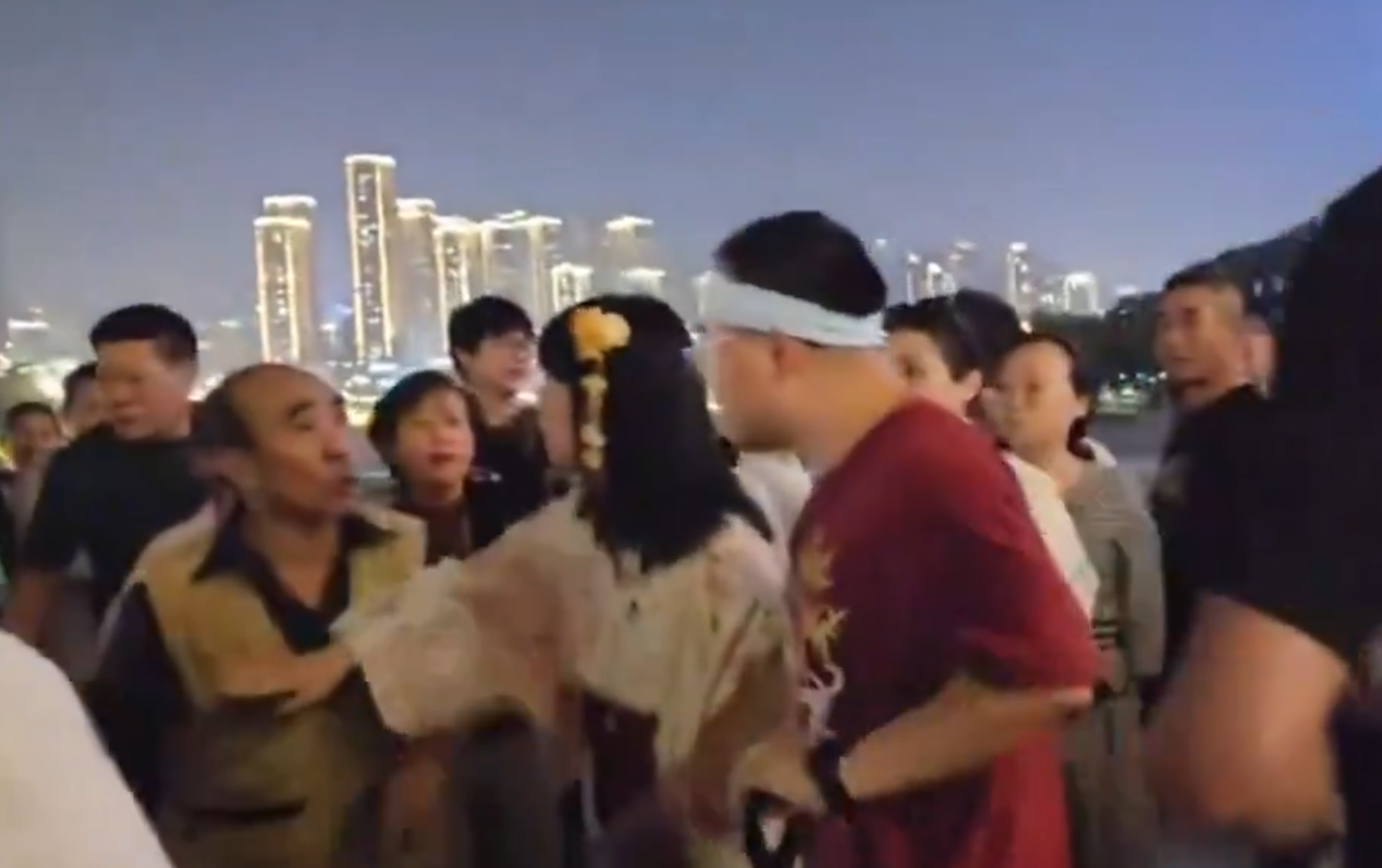 重慶市兩名女子上周六(27日)在南濱路博覽館前,穿着和服跳舞並拍攝影片,吸引路人圍觀,期間有一群長者聲討制止表不滿,雙方一度有肢體衝突,最終公安介入。(影片截圖)