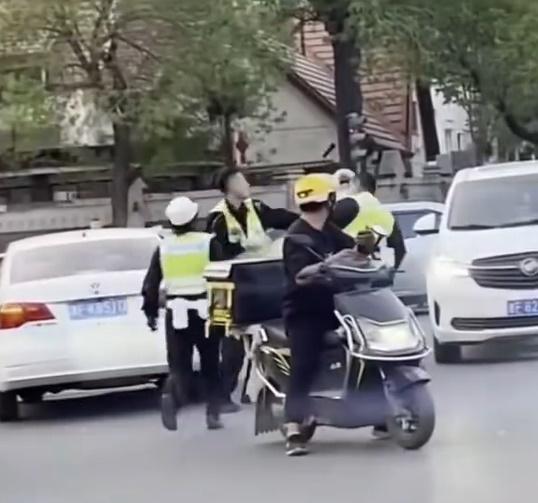 一名女交通警員小跑上前勸阻,但兩人未有理會,亦沒有停手。(微博)