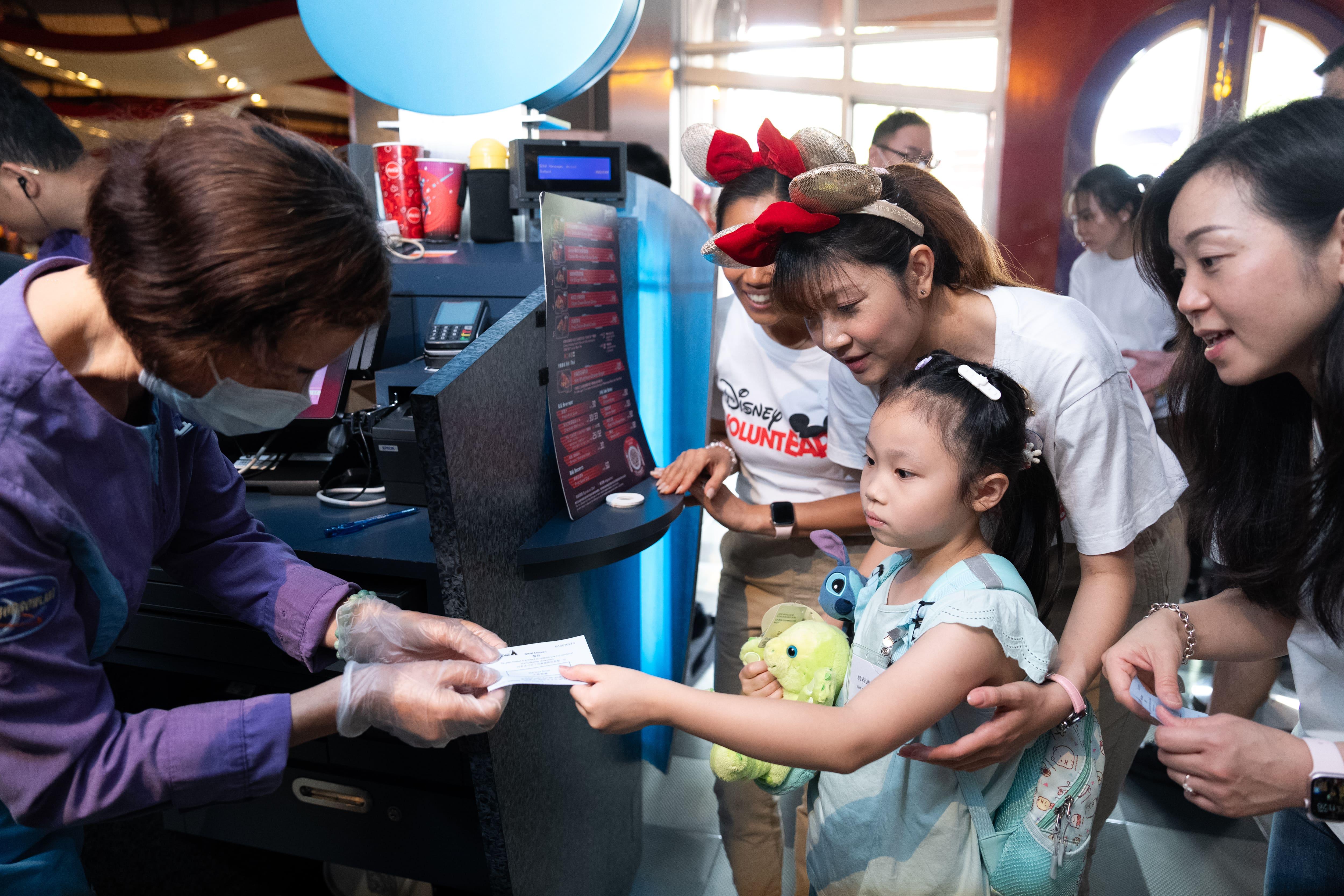 7歲允妍的患有自閉症,在包容的環境和迪士尼義 工的陪伴下,允妍可以嘗試自行購物、付款,情況大大改善。(林靄怡攝)