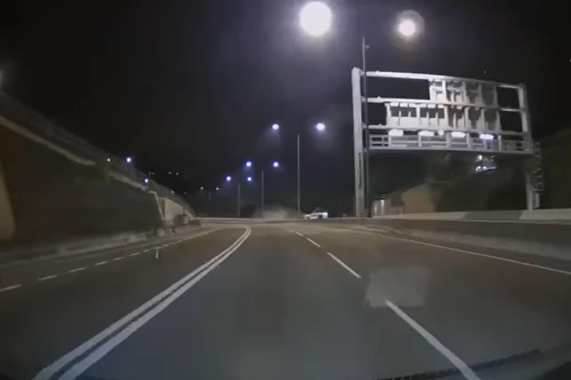 網上有車Cam片顯示,涉事私家車先撞向路中分隔石壆,再翻轉兩圈撞向左邊龍門架,其間在路中揚起塵土。(網上影片截圖)