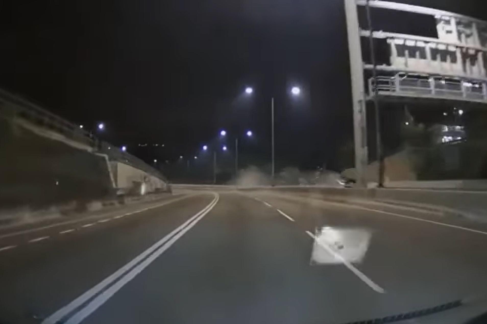 網上有車Cam片顯示,涉事私家車先撞向路中分隔石壆,再翻轉兩圈撞向左邊龍門架,其間在路中揚起塵土。(網上影片截圖)