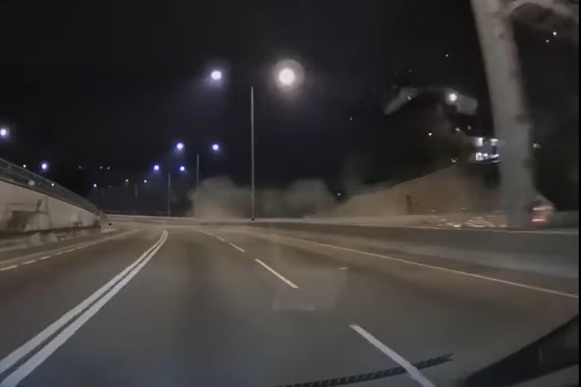 網上有車Cam片顯示,涉事私家車先撞向路中分隔石壆,再翻轉兩圈撞向左邊龍門架,其間在路中揚起塵土。(網上影片截圖)