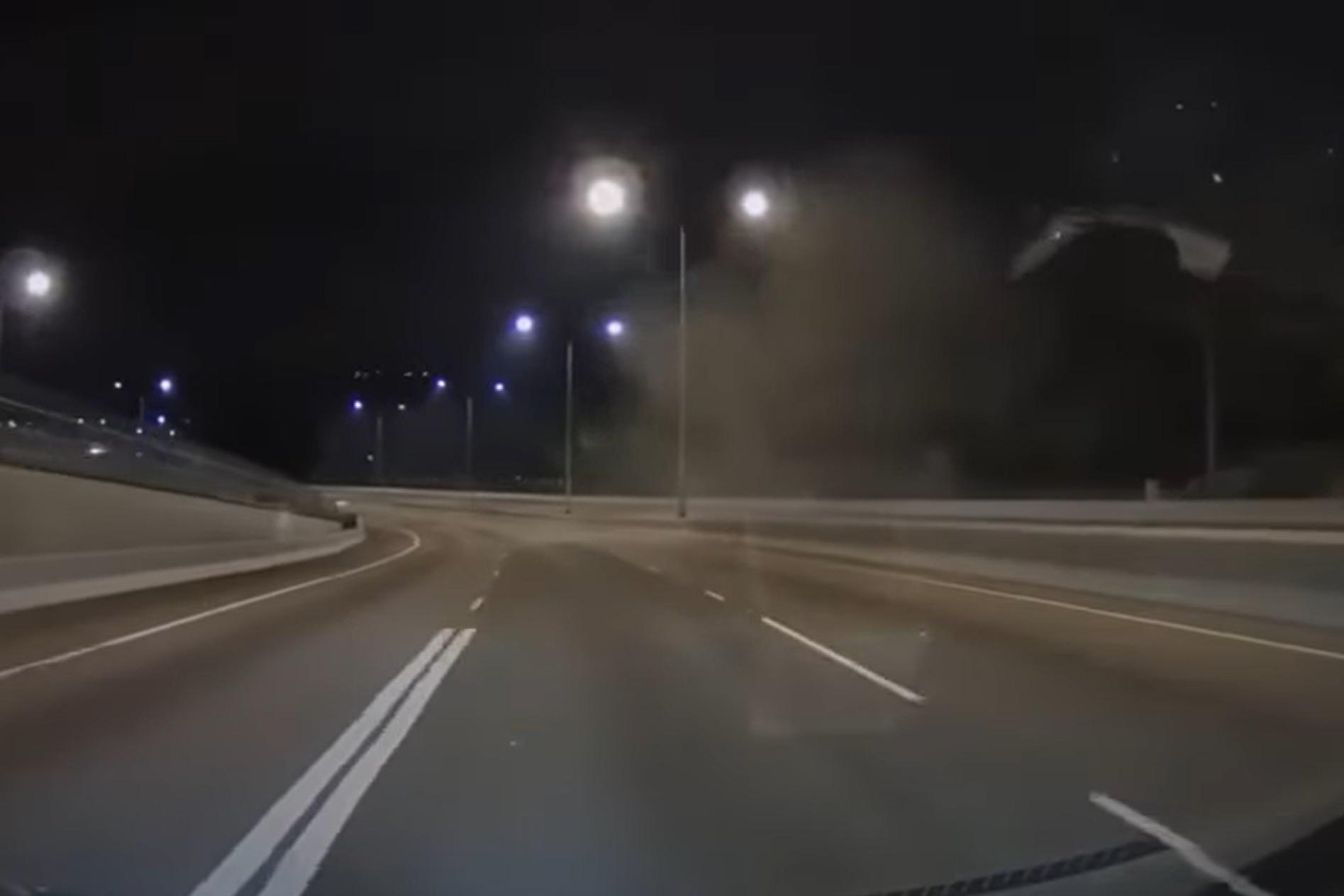 網上有車Cam片顯示,涉事私家車先撞向路中分隔石壆,再翻轉兩圈撞向左邊龍門架,其間在路中揚起塵土。(網上影片截圖)