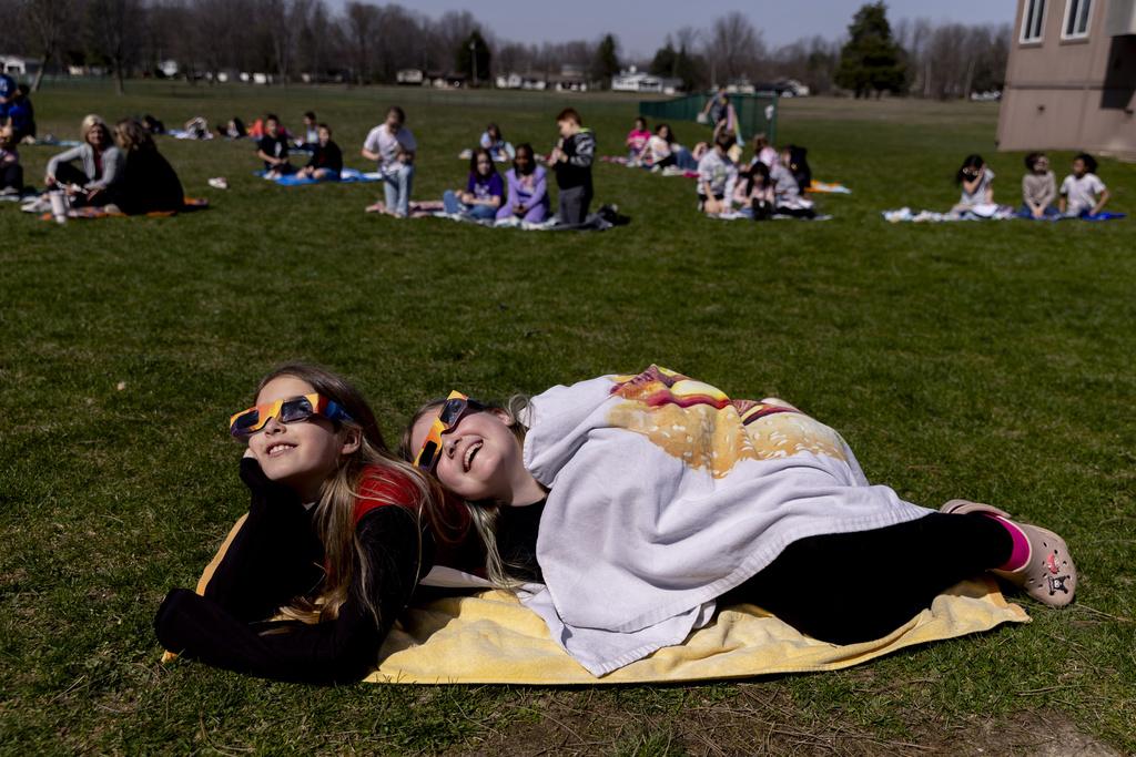 美國密歇根州小學一對好姊妹一起觀看日全食。(美聯社)