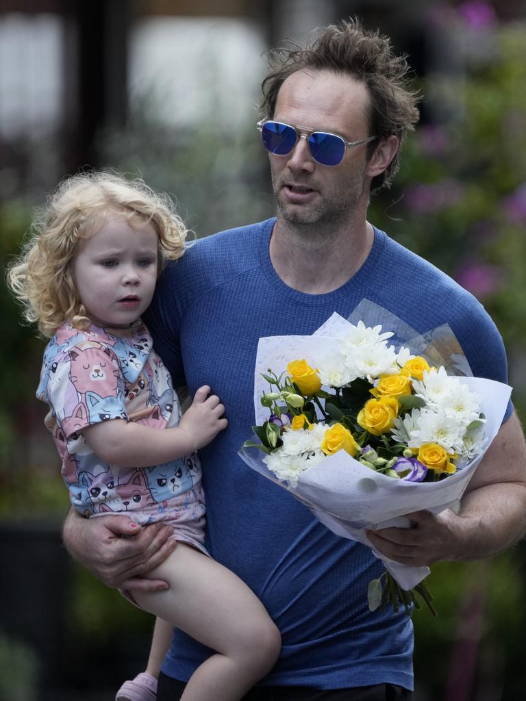 悉尼居民帶同女兒前往案發商場外獻花,悼念遇難者。(美聯社)