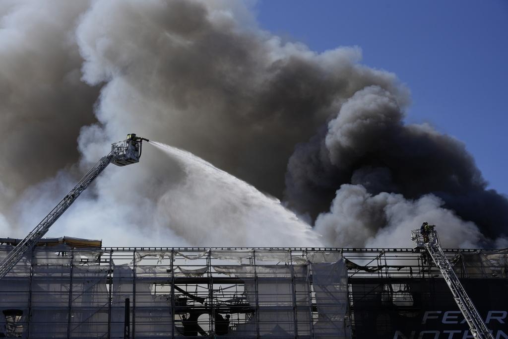 現場濃煙密布,消防奮力灌救。(美聯社)