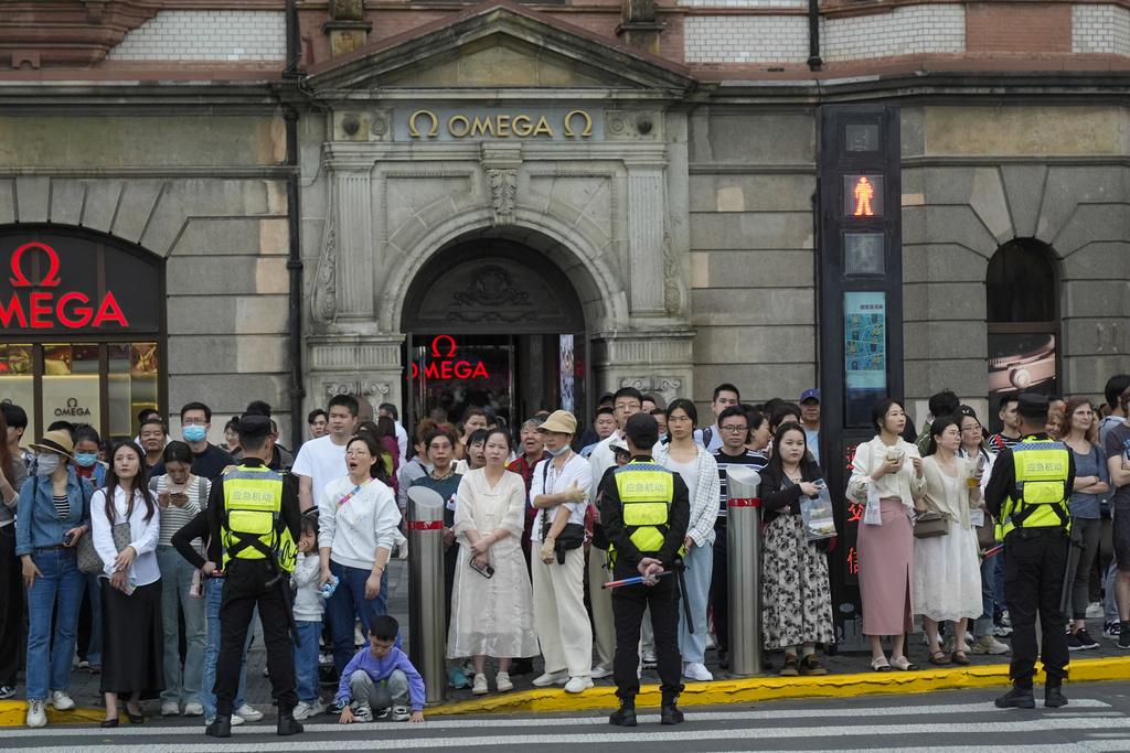 布林肯的車隊在中國上海外灘行駛時,人群排成一排。(AP)