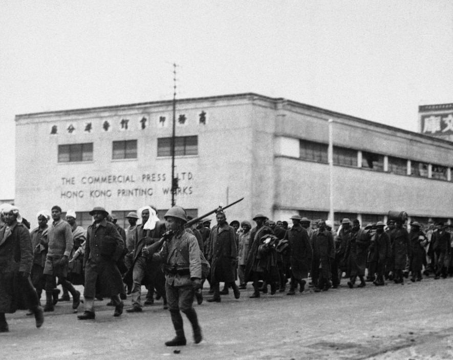 日佔時期,商務印書館的把總部由上海遷至香港,後來香港淪陷,香港商務損失慘重,並把業務重心移至重慶。圖片攝於1941年12月,被日本兵看守的印度戰俘行經北角商務印書館的印刷廠房。(網上圖片)
