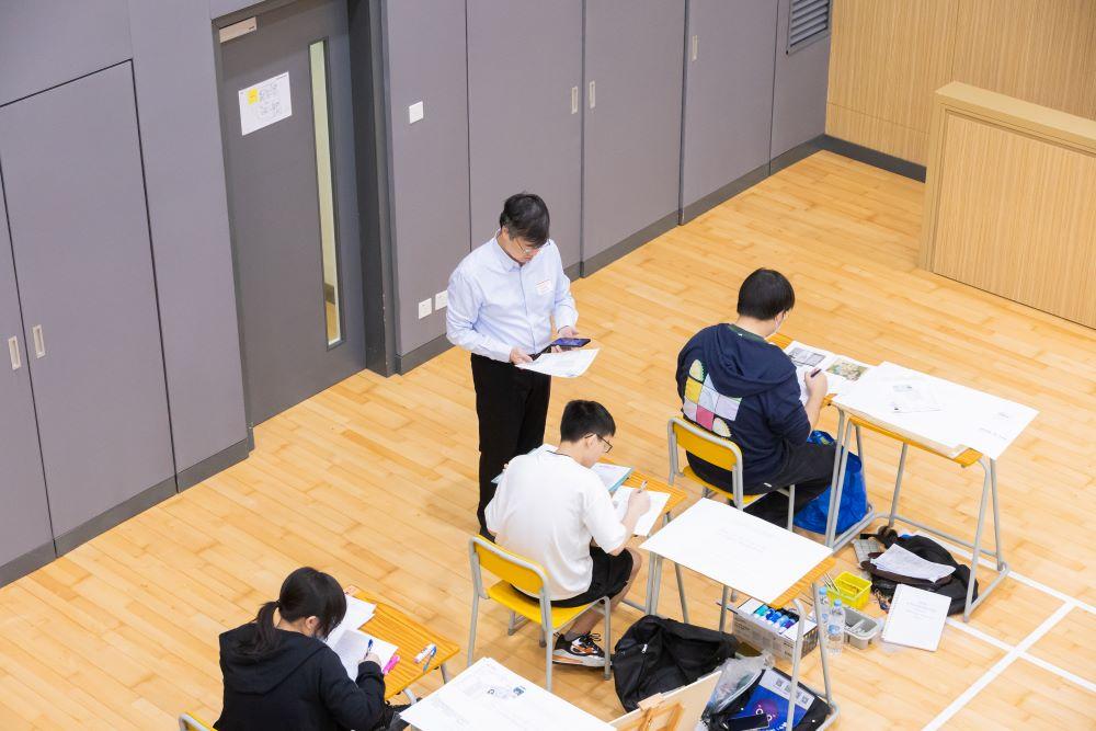 DSE 2024|監考員透過流動裝置查閱考生於報名時提供的相片及資料,核實考生身分。(考評局圖片)