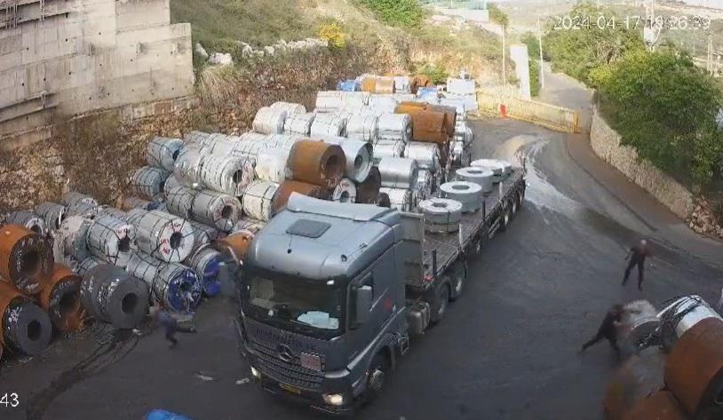 工人雙手猛推,試圖阻擋巨大鋼捲。(互聯網)