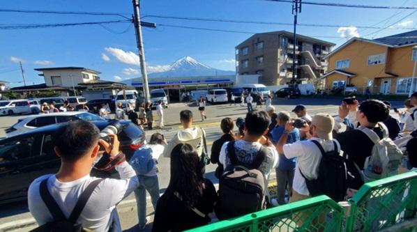 大批遊客在LAWSON河口湖站前店附近拍照。(互聯網)