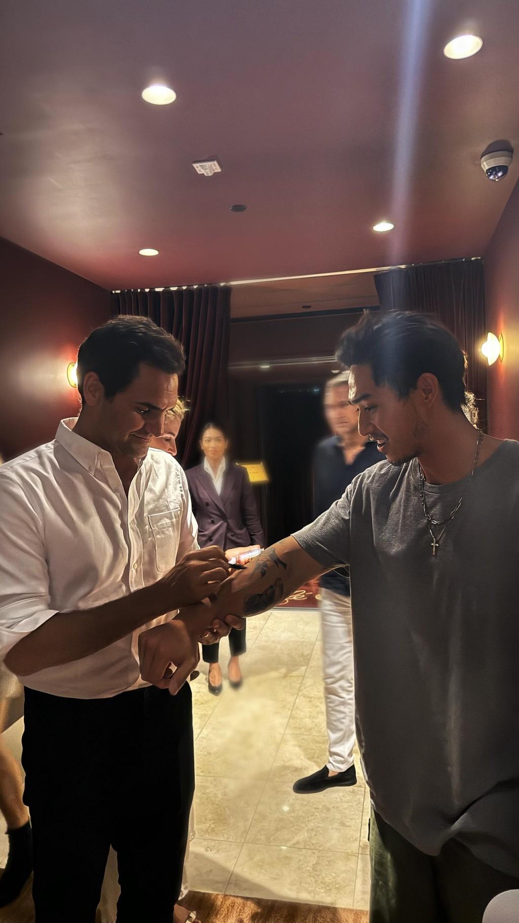 胡智同伸出右手向費達拿索簽名。