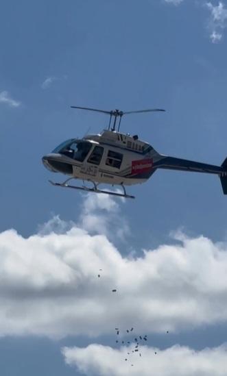 直升機撒下鈔票。(互聯網)