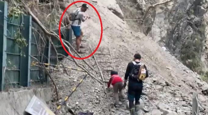 Dimitris Belbas捉緊繩索協助警員帶走受困小孩,小孩慢慢攀上梯子。(互聯網)