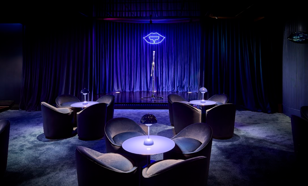 氣派十足天鵝絨休閑沙發低椅及長約6米寬天鵝絨沙發、小圓枱、別緻藍色圓枱燈,懸掛鏡面天花投射現代感的奢華面貌,兼備藍灰色地毯為空間增添舒適感,忙碌一天後來到這裡,放鬆休息讓人忘返游走於感官與美酒之間。