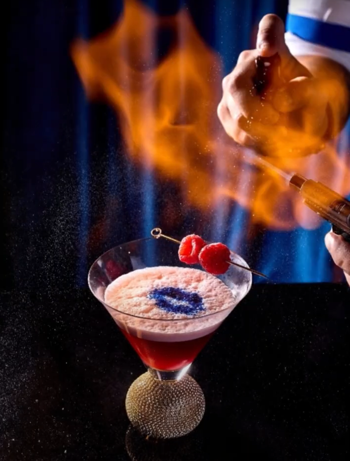 Kiss Kiss雞尾酒,採用精緻H by Hine干邑、Cocchi Rosso 苦艾酒、新鮮香橙、紅石榴糖漿及砵酒混合而成,是花香、果香及辛辣搭配的完美結晶,最後噴灑苦艾酒帶來火熱餘韻;頂部清爽泡沫刻印著迷人吻痕,喚醒輕吻肌膚帶來輕柔甜蜜觸感。