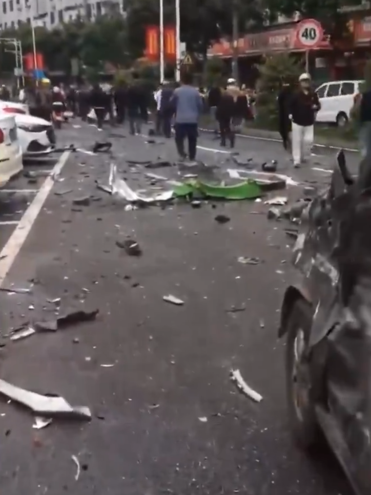 江西贛州一輛Tesla Model Y電動車行駛時,疑因緊急避讓行人操作不當,撞上道路設施和停在路邊的車輛,車輛凌空飛起,翻滾多圈砸壞路上約9輛車,造成4人受傷。(影片截圖)